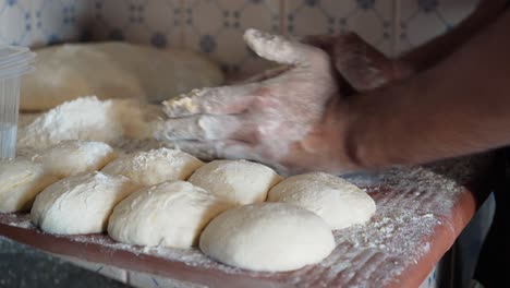 Baker-shaping-bread-loaf-dough-with-flour-in-hands