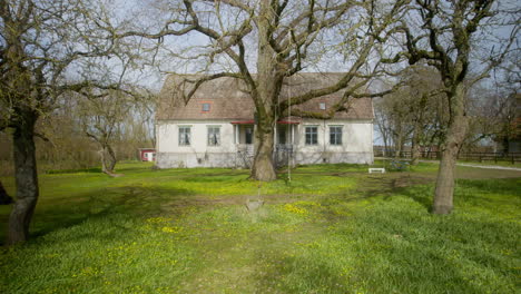 Altes-Herrenhaus-Mit-Einem-Großen-Baum-Im-Garten-Im-Frühling