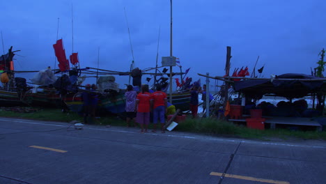 Menschen-Schützen-Buntes-Holzboot-Bei-Starkem-Wind-In-Songkhla,-Thailand,-Abends-Blaues-Licht