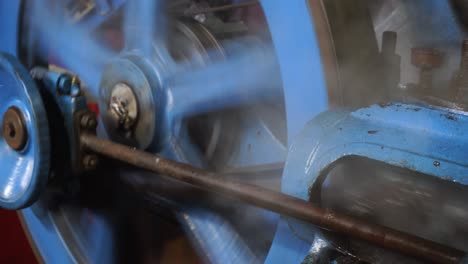 Blue-industrial-machine-moved-by-a-steam-engine-releasing-working-fluid-steam-and-rotating-in-a-mechanical-manner