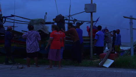Personas-Que-Protegen-El-Barco-De-Madera-Tradicional-En-La-Orilla-Con-Fuertes-Vientos-En-Tailandia