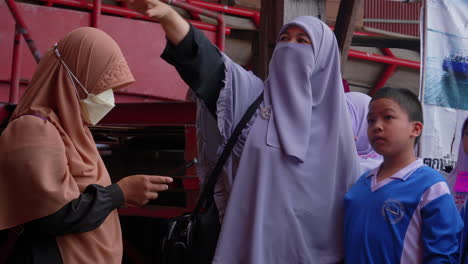 Female-Muslim-teacher-in-hijab-teaching-young-students-during-visit-in-Songkhla,-Thailand