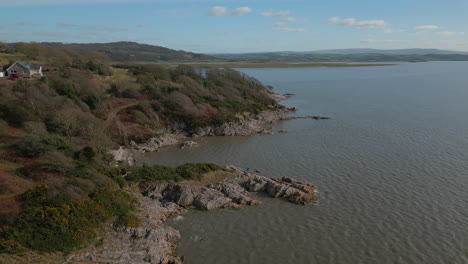 High-view-of-hiker-on-rocky-outcrop-with-ocean-reveal-at-Jenny-Brown's-Point-Silverdale-UK