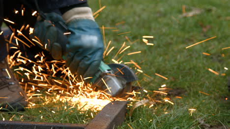 Sparks-Flying-on-Rusty-Old-Metal-with-Worker-Using-Angle-Grinder-Wearing-Protective-Gloves-and-Overalls