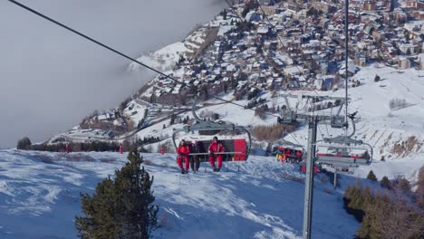 View-from-a-chairlift-of-others-going-up-with-people-to-ski-in-the-snowy-mountains