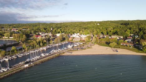 Sandy-beach-near-private-boats-dock-in-Suttons-Bay,-aerial-drone-view