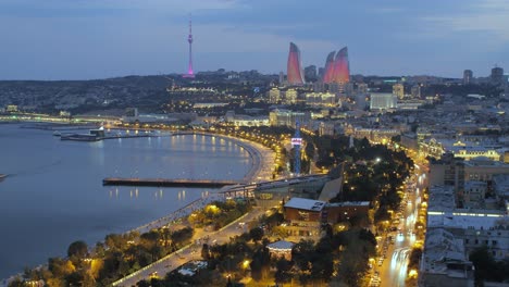 Lufttrimelapse-Von-Baku-Bei-Sonnenuntergang-Mit-Leuchtenden-Flammentürmen