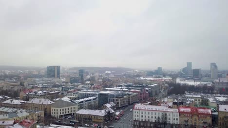 Upwards-aerial-movement-revealing-the-old-town-of-Vilnius-during-a-snowstorm