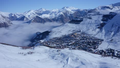 Kleines-Dorf-Auf-Hohen-Schneebedeckten-Bergen-In-Den-Alpen
