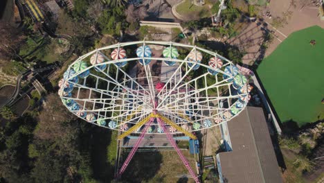 Ferris-wheel-spins-in-a-small-theme-park---top-down-to-pullback-reveal-shot