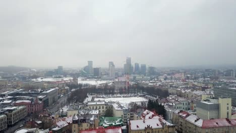 Aerial-tracking-shot-above-the-old-town-of-Vilnius-during-a-winter-snowstorm