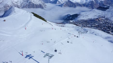 Drohne-Fängt-Tagsüber-Viele-Skifahrer-Ein,-Die-Auf-Einem-Verschneiten-Hohen-Berg-Ski-Fahren