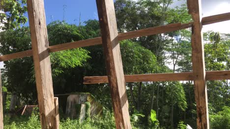 Antigua-Casa-Abandonada-En-Ruinas-Con-Luz-Solar,-Cielo-Azul-Y-Bosque-De-Bambú-Verde-Como-Fondo