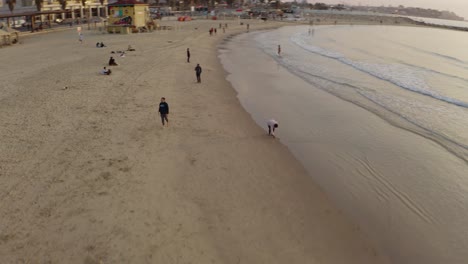 4K-Luftaufnahme-–-Majestätische-Orbitmenschen-Am-Strand-Von-Tel-Aviv-Bei-Sonnenuntergang