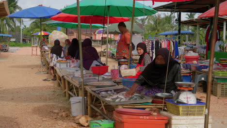 Muslim-women-in-hijabs-selling-seafood-in-local-farmer's-market-in-Thailand