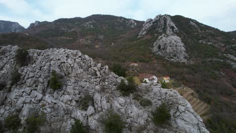 Houses-built-in-the-valley-between-the-rocky-ranges,-high-mountains-with-steep-slopes-in-the-north-of-Albania