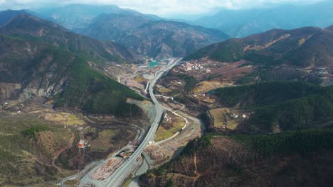Transportation-road-through-beautiful-valley-in-Albania,-highway-leading-towards-mountain-range