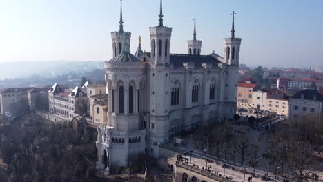 Beautiful-Aerial-Orbit-View-of-the-Basilica-Notre-Dame-de-Fourvière-and-Metallic-Tower-Overlooking-Lyon-City,-Sunny-Day
