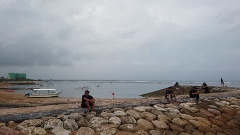Dock-in-Sanur-Beach-Bali-Indonesia,-People-Sit,-Boats-Docked,-Balinese-Sea,-Indonesia,-Southeast-Asia-Travel-Destination