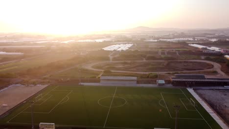 Aerial-backwards-shot-of-soccer-field-and-Atlantic-Ocean-during-sunset-time-in-Portugal