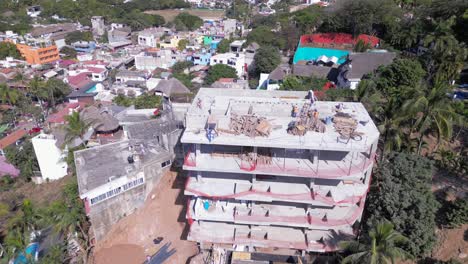 A-drone-captures-construction-workers-atop-of-a-new-building-being-built-upon-a-mountain-in-Sayulita-Mexico
