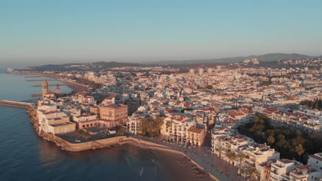 Küstenstadtbild-Drohnenperspektive-Während-Der-Goldenen-Stunde-Mit-Gebäuden,-Meer,-Bergen