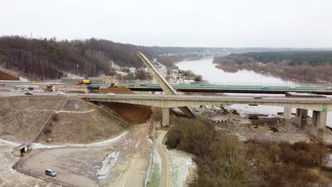 Kaunas-city-A1-highway-collapsed-bridge-during-snowfall,-aerial-descend-view