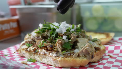 Sprinkling-onions-on-a-chicken-cheesesteak-sub---food-truck-series