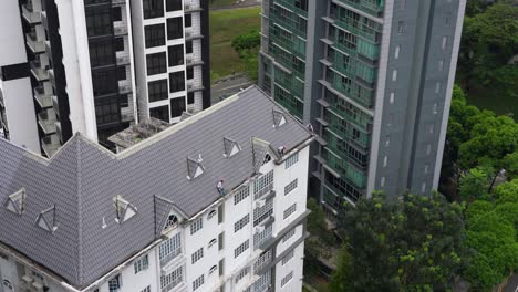 Three-roofers-are-doing-roofing-work-on-top-of-an-apartment-in-Singapore