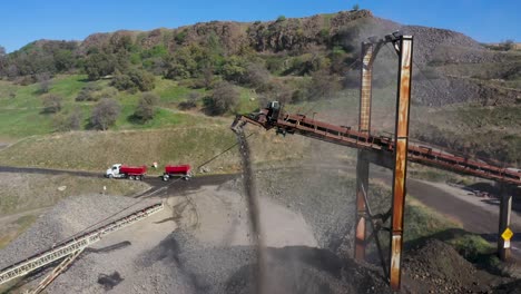 Aerial-reveal-shot-of-a-conveyor-belt-transporting-rock-in-a-quarry