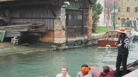 Venetian-Gondolier-passing-Gondola-boatyard