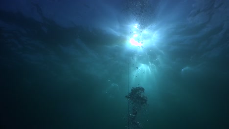 Ascend-line-leading-to-the-ocean-surface-with-sun-rays-streaming-down-the-water