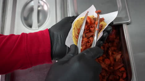 Putting-marinated,-pulled-pork-on-a-soft-taco-shell---food-truck-series