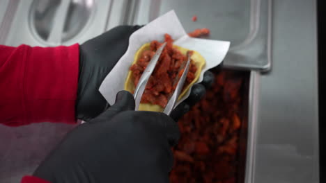 Filling-a-corn-tortilla-with-pork-for-street-tacos---food-truck-series