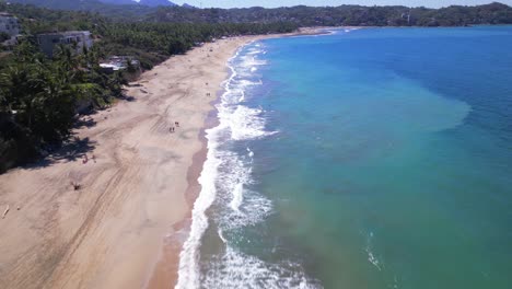 The-beach-at-Sayulita-Mexico-has-waves-crashing-upon-the-long-sandy-beach-during-a-sunny-day