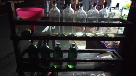 Benzinglasflaschen-In-Einer-Asiatischen-Straßentankstelle,-Typischer-Gelagerter-Nachfüllkraftstoff-Auf-Bali,-Indonesien,-Stadt-Denpasar