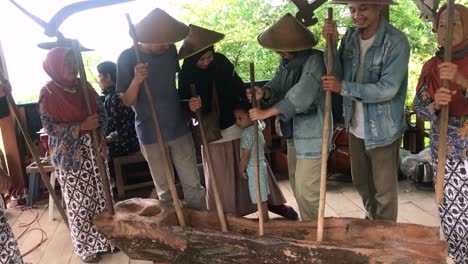 The-art-of-"gejog-dimples"-is-a-musical-art-that-plays-a-musical-instrument-in-the-form-of-a-hollow-wooden-object-resembling-a-canoe-called-"lesung",-which-is-usually-used-as-a-place-to-pound-rice