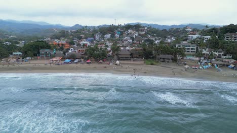 Eine-Drohne-Fliegt-über-Uns-Und-Zeigt-Den-Strand-Und-Die-Stadt-Sayulita,-Mexiko