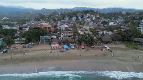 A-drone-flies-overhead-showing-the-beach-and-town-of-Sayulita-Mexico