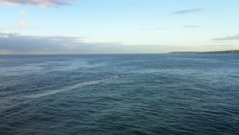 A-small-boat-travels-across-the-ocean-during-the-early-morning-in-Eastern-Suburbs-of-Sydney,-near-Bondi-Australia