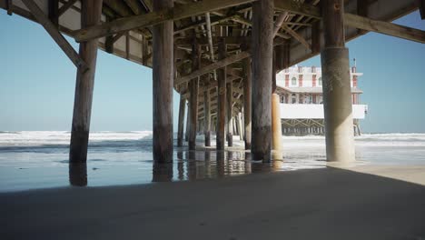 Under-the-pier-people-walking-waves-crashing-on-the-pier