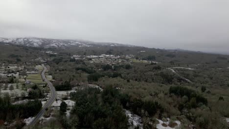 Snowy-village-with-vegetation-in-winter-under-a-cloudy-sky-in-Picornio,-a-village-in-Galicia
