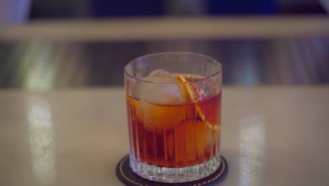 Barkeeper-Schenkt-Einen-Martini-Mit-Orange-Und-Eis-Ein