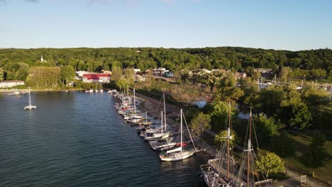 Antique-sail-ship-in-docks-of-Suttons-Bay,-Michigan,-aerial-drone-ascend-view
