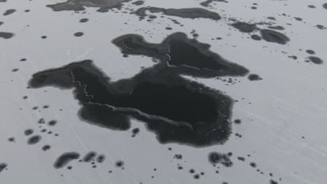 Frozen-lake-from-above-with-black-and-white-patterns-from-ice