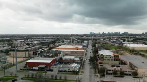 Aerial-view-towards-a-suburban-warehouse-construction-area-in-cloudy-Houston,-USA