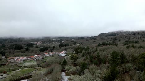 Snowy-village-surrounded-by-nature-in-winter-under-a-cloudy-sky-in-Picornio,-a-village-in-Galicia