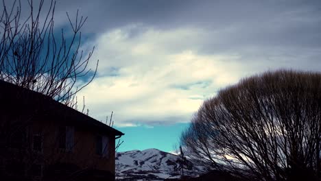 Storm-rolling-in-over-the-backyard-and-snowy-mountains---cloudscape-time-lapse