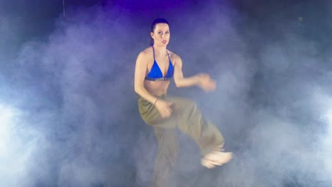 Junge-Kaukasische-Moderne-Tänzerin,-Die-In-Einem-Verrauchten-Studioraum-Eine-Geschwindigkeitsrampe-Vorführt
