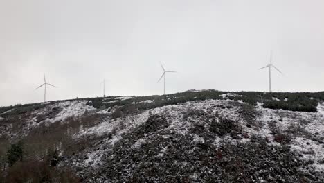 Snowy-hill-with-3-modern-windmills-on-a-cloudy-day